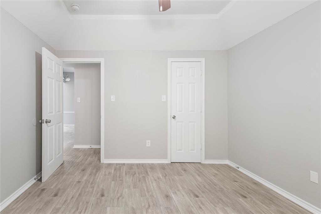 304 Moore Creek Road, Unit 300 Hurst, TX 76053 - Photo 12 of 17 Spacious room with light gray walls, wood-finish flooring, and white baseboards
