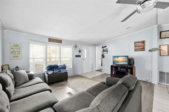 a living room with furniture a flat screen tv and a window