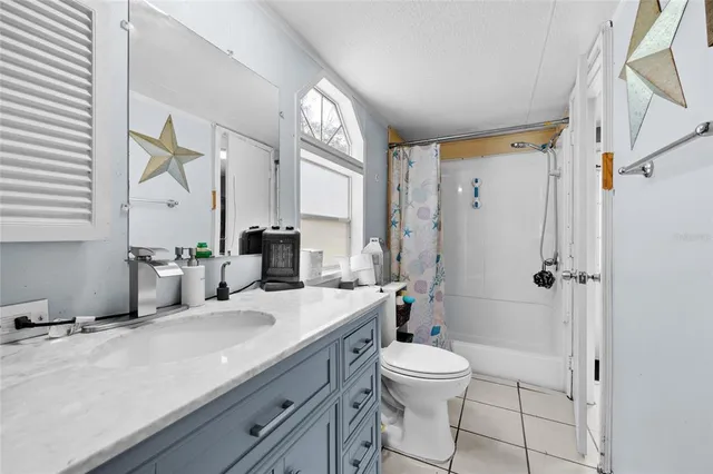 a bathroom with a double vanity sink toilet mirror and shower