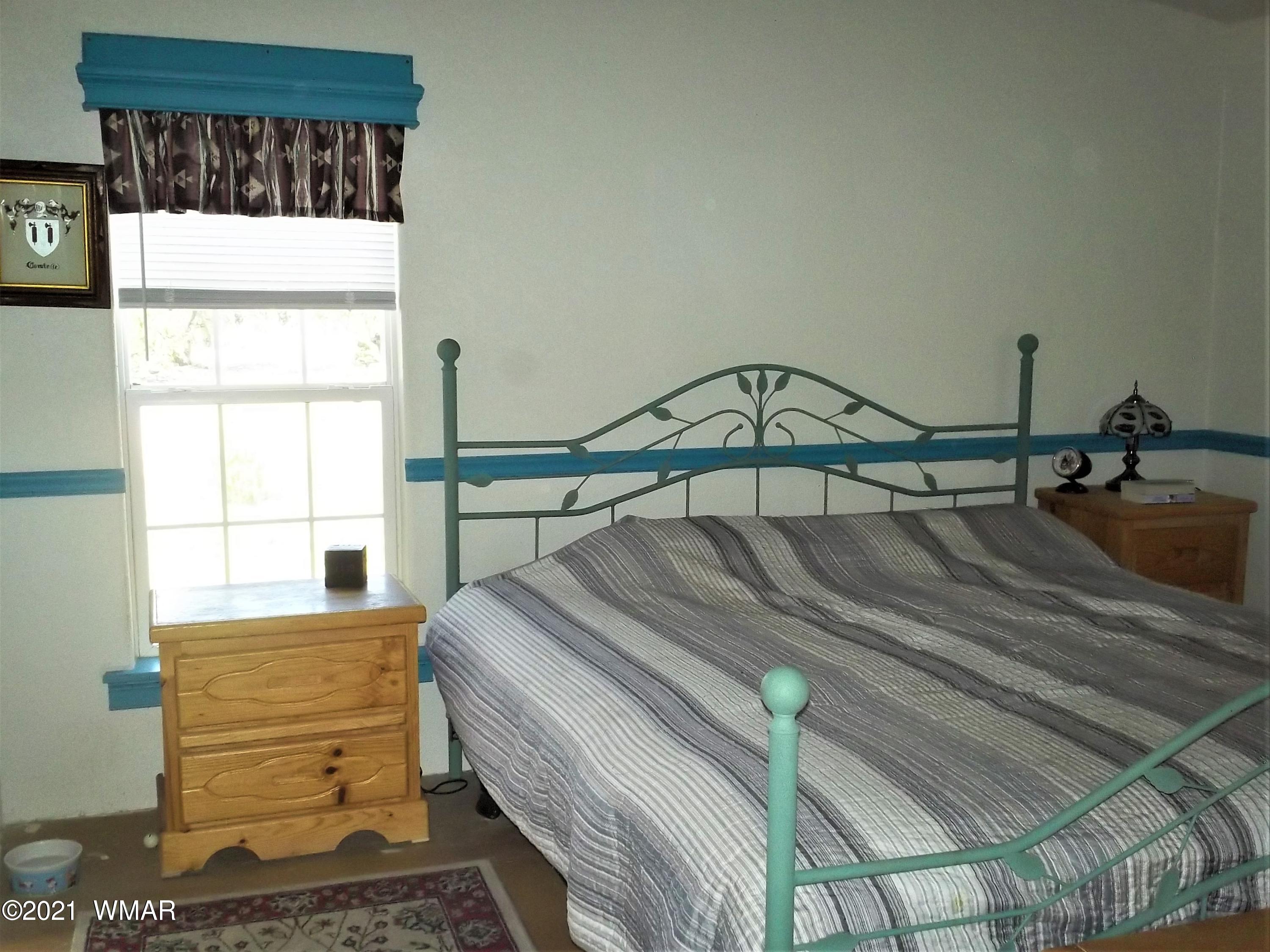 6 N3097 Vernon, AZ 85940 - Photo 26 of 40 a bedroom with a bed a mirror and a window
