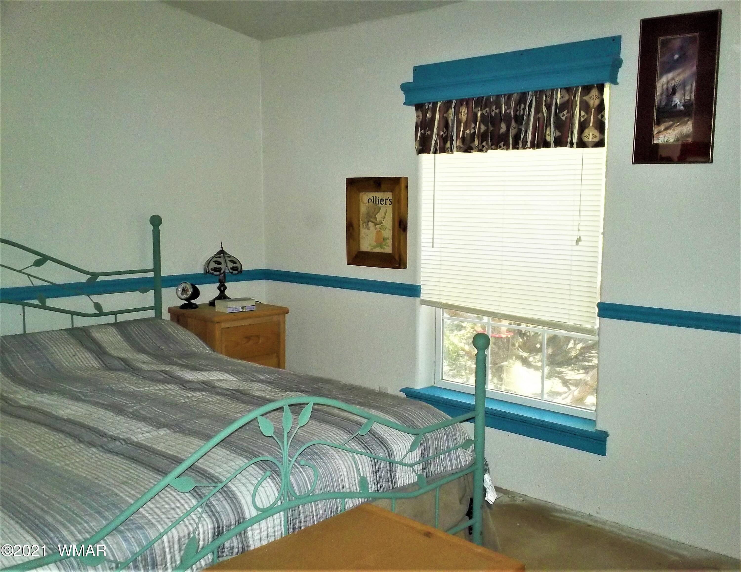 6 N3097 Vernon, AZ 85940 - Photo 27 of 40 a bed sitting in a bedroom next to a window