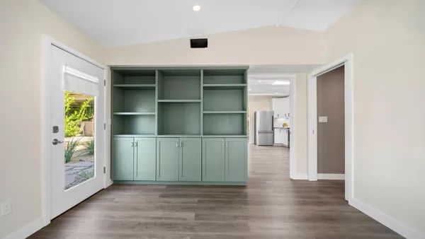 a view of an empty room with wooden floor and closet