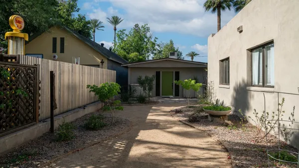a view of a backyard with chairs and a potted plant