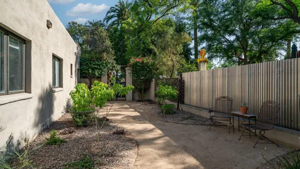 a backyard of a house with table and chairs potted plants