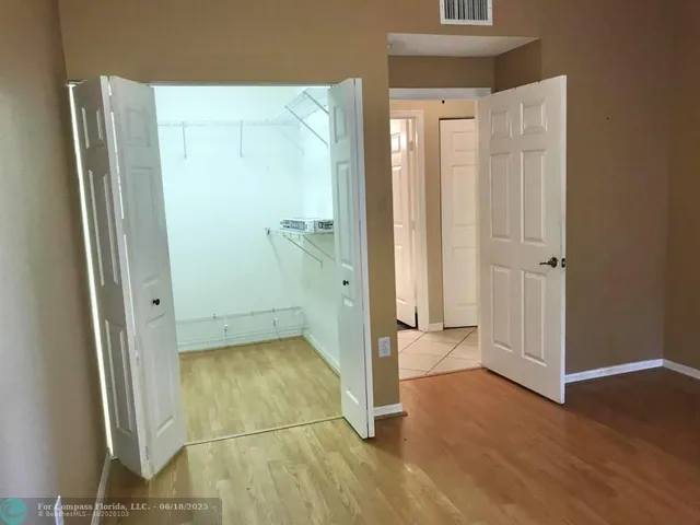 an empty room with wooden floor and a bathroom