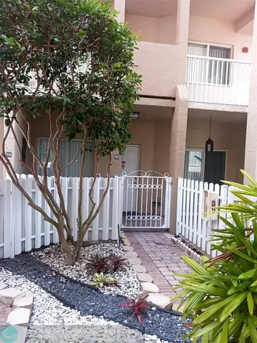 a view of a house with a small yard and wooden fence