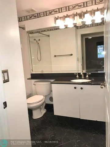 a bathroom with a toilet a sink and mirror