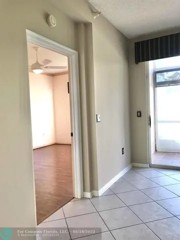a view of a hallway with wooden floor and a cabinet