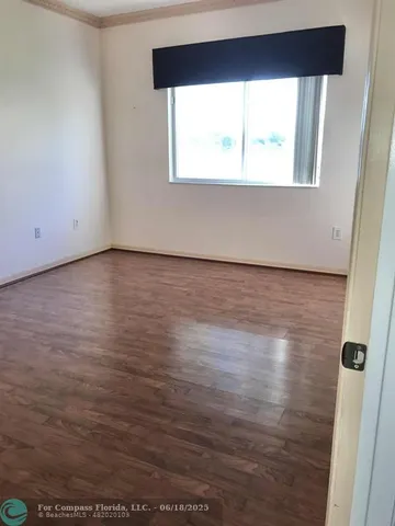 a view of a room with wooden floor and window