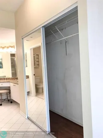 a view of a hallway with wooden floor and windows