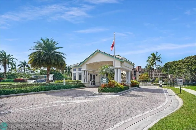 a front view of a house with a yard and palm trees