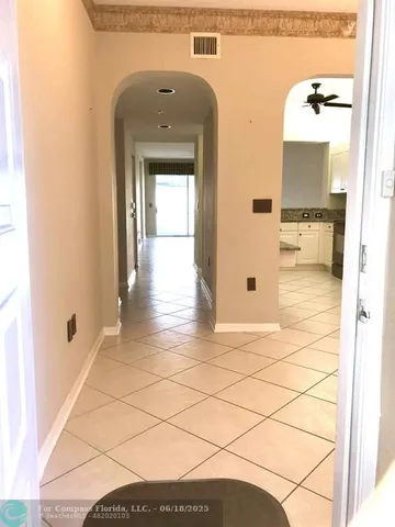 a view of a hallway with wooden floor and a bathroom