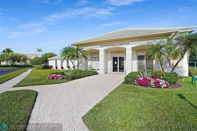 a front view of a house with a big yard and potted plants