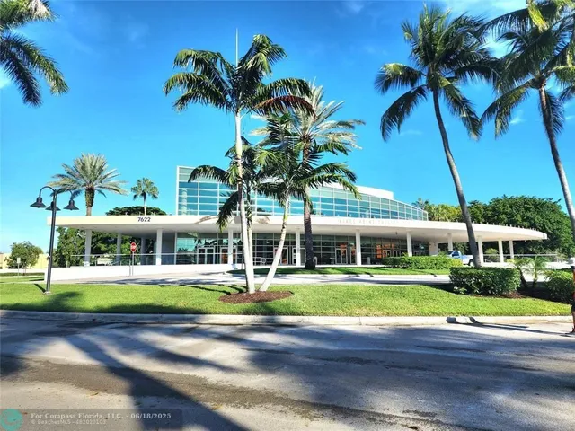 a view of a building with garden and tall trees