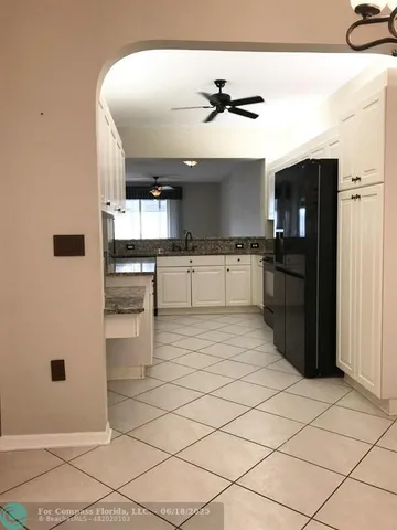 a kitchen with stainless steel appliances kitchen island granite countertop a refrigerator and a sink
