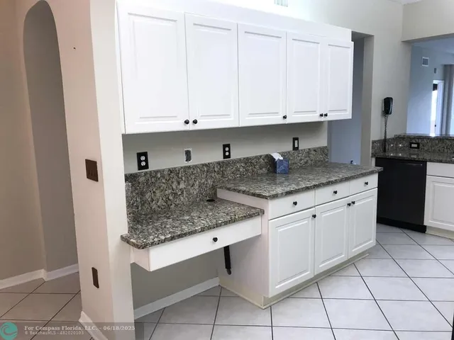 a kitchen with granite countertop white cabinets and stainless steel appliances