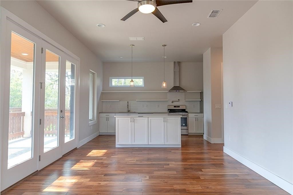 2509 Del Curto Road, Unit A Austin, TX 78704 - Photo 2 of 23 a kitchen with kitchen island granite countertop a sink cabinets and wooden floor