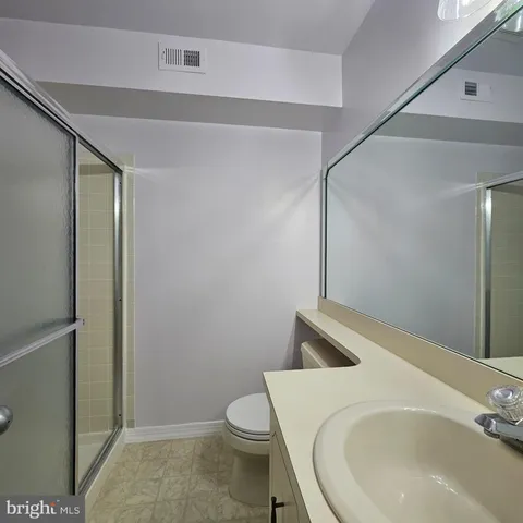 a white toilet sitting next to a bathroom sink and a shower