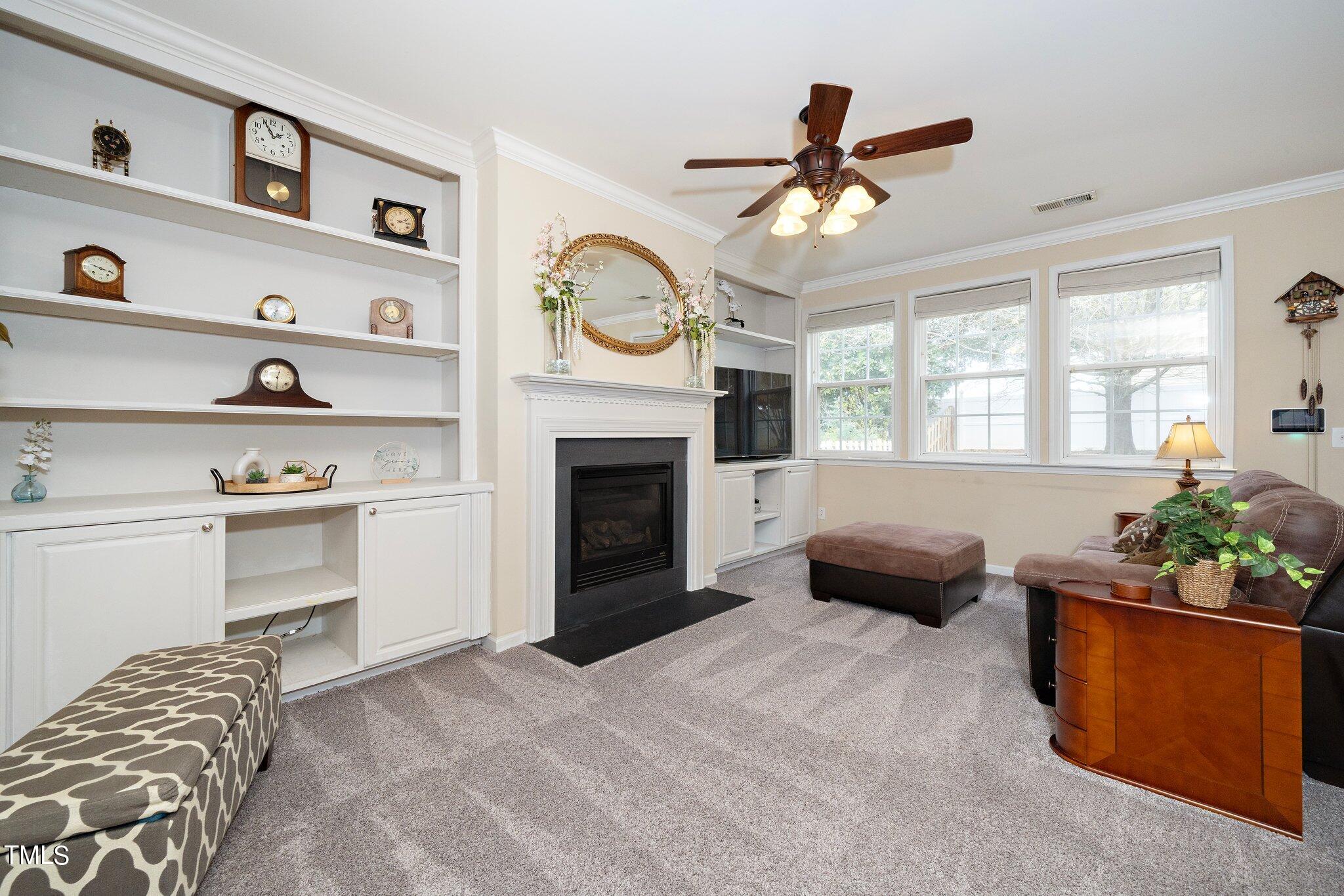 120 Solheim Lane Raleigh, NC 27603 - Photo 14 of 26 a living room with furniture a fireplace and a window