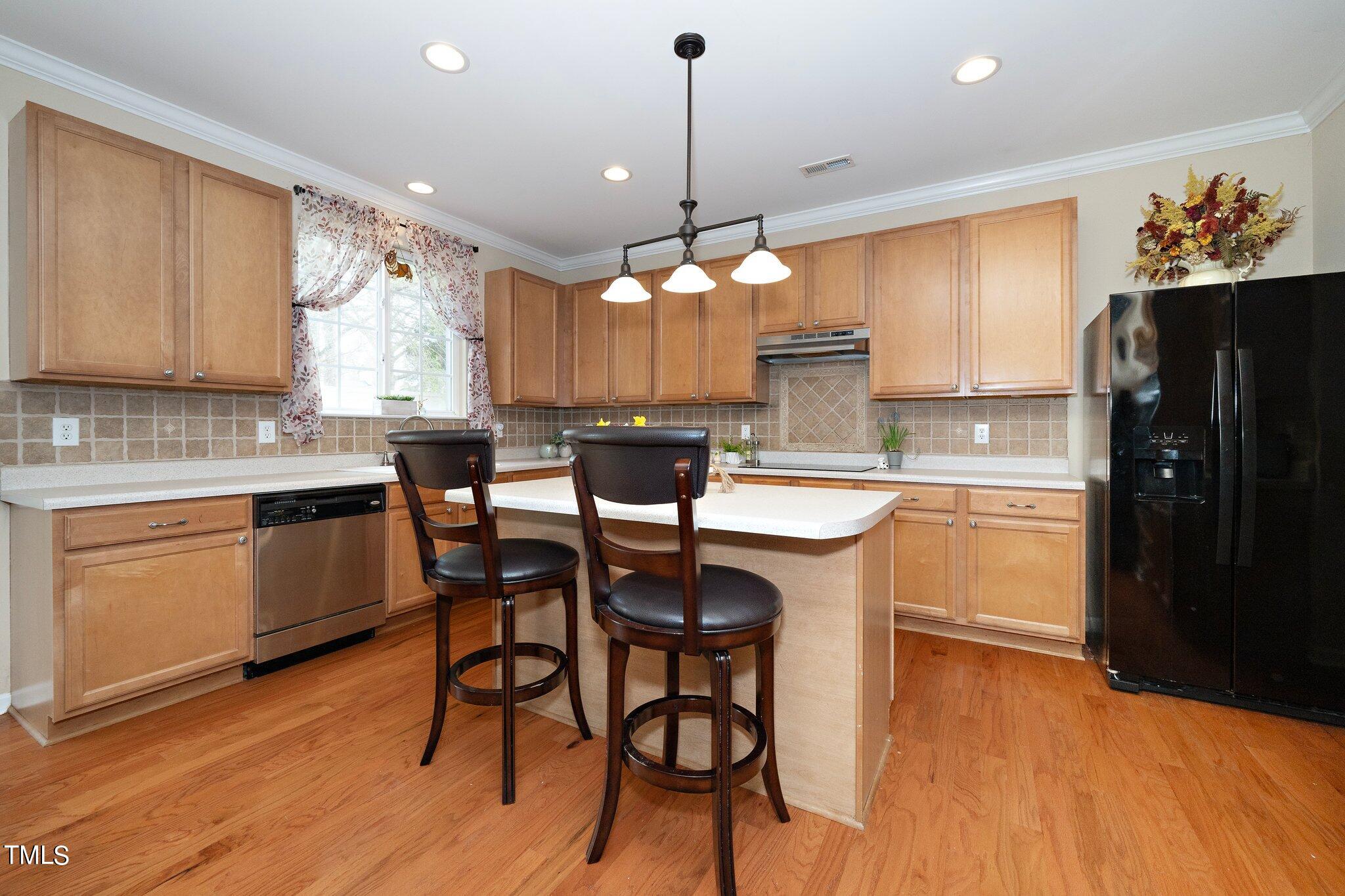 120 Solheim Lane Raleigh, NC 27603 - Photo 3 of 26 a kitchen with a dining table chairs sink and cabinets