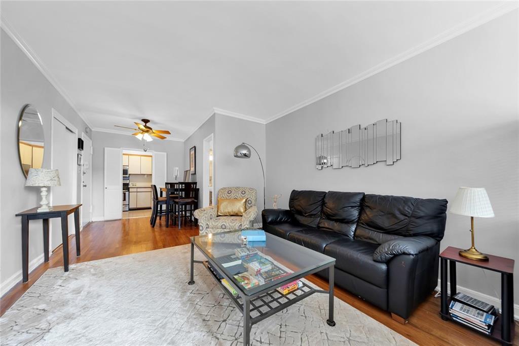 9201 Shore Road, Unit C701 Brooklyn, NY 11209 - Photo 2 of 9 a living room with furniture and a dining table with wooden floor