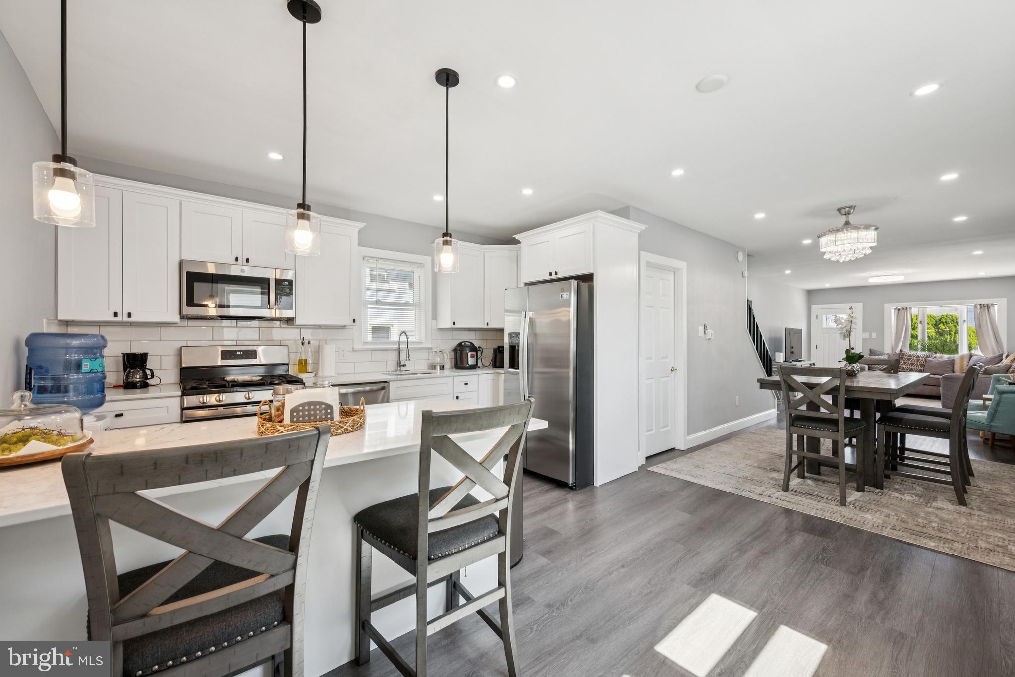 259 Hooker Street Riverside, NJ 08075 - Photo 13 of 25 a kitchen with stainless steel appliances a dining table chairs refrigerator and microwave