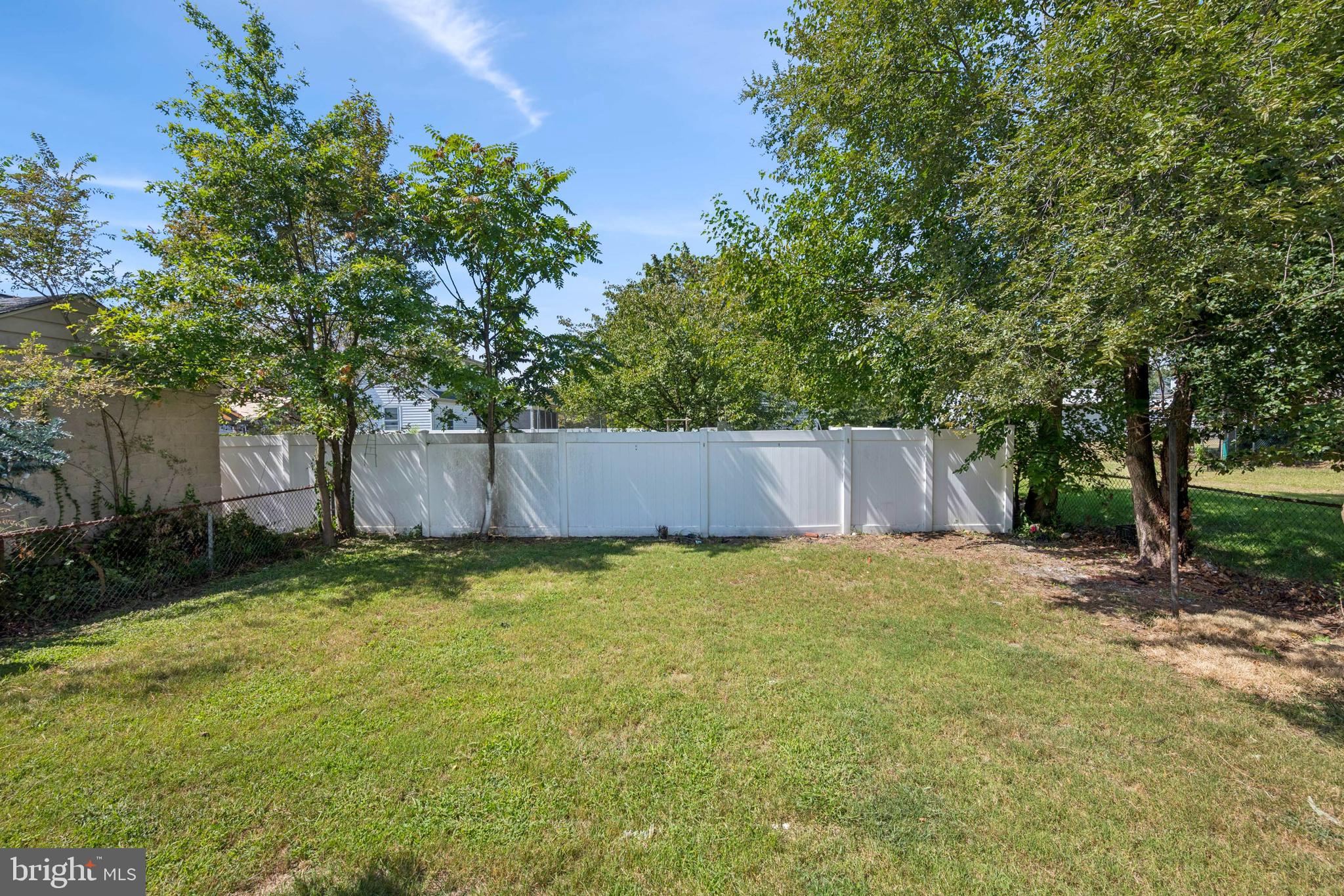 259 Hooker Street Riverside, NJ 08075 - Photo 23 of 25 a backyard of a house with lots of plants and large tree