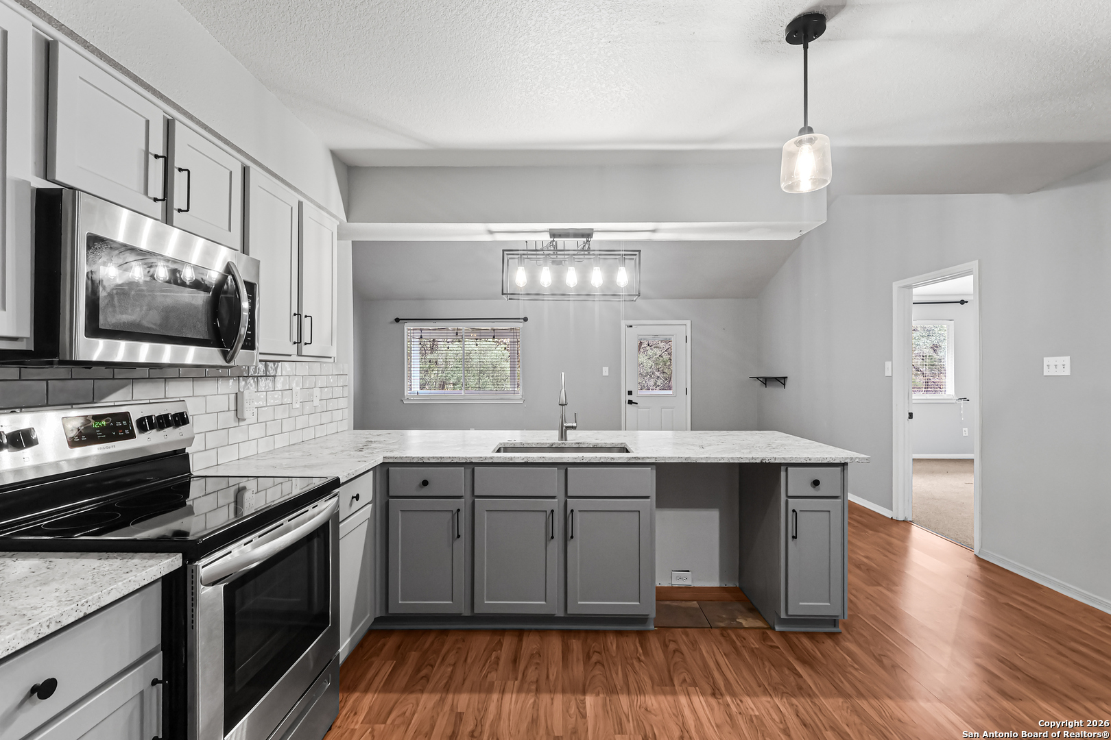 162 Canyon View Court Spring Branch, TX 78070 - Photo 21 of 44 a kitchen with a sink stove and wooden floor