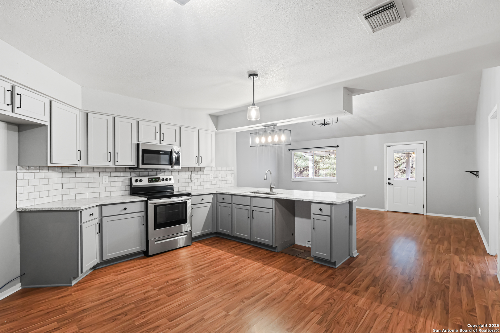 162 Canyon View Court Spring Branch, TX 78070 - Photo 22 of 44 a large kitchen with cabinets wooden floor and stainless steel appliances