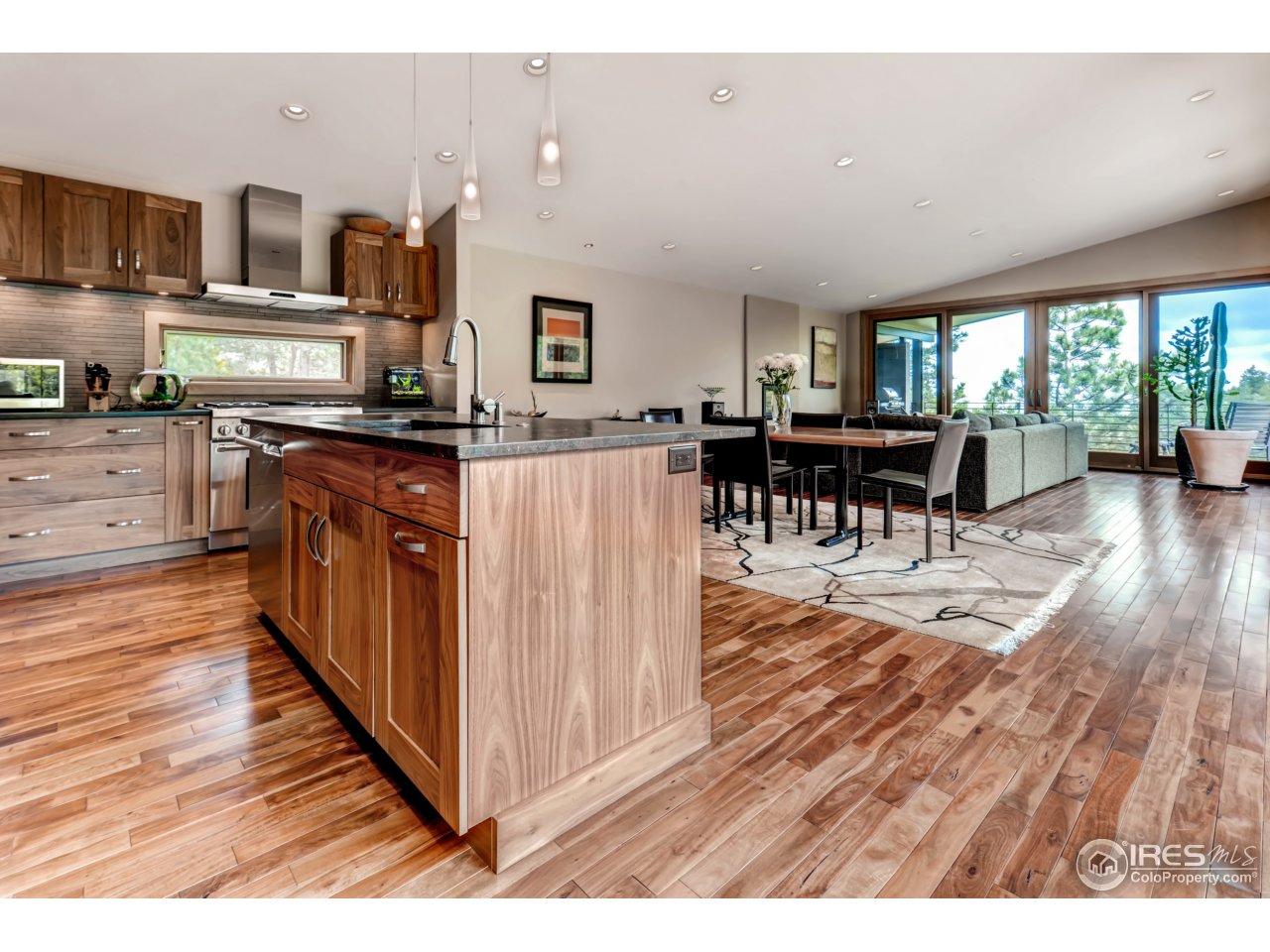 153 Brook Road Boulder, CO 80302 - Photo 5 of 25 a kitchen with stainless steel appliances kitchen island granite countertop a refrigerator a stove top oven a dining table and chairs with wooden floor