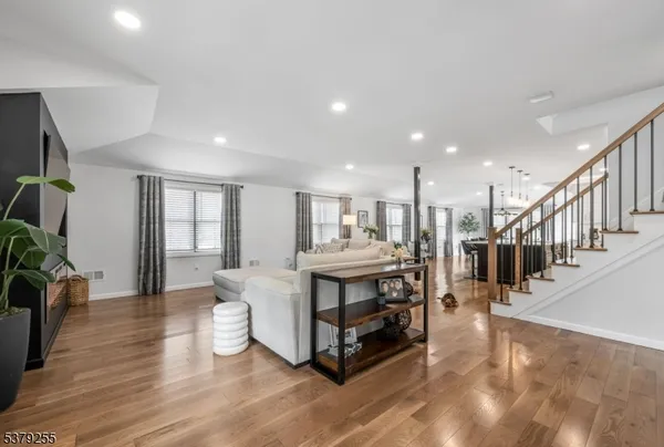 a living room with lots of wooden furniture and a kitchen view