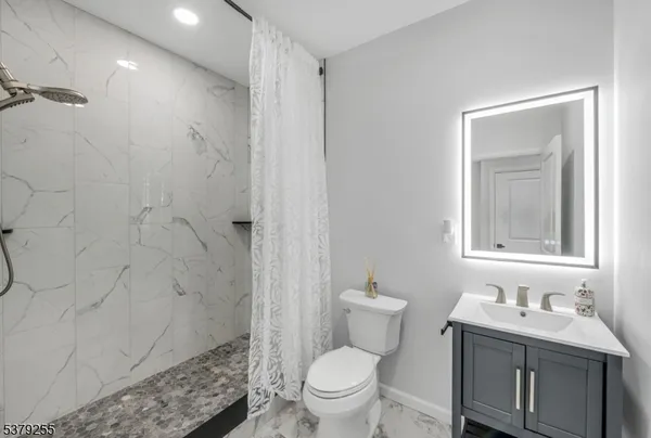 a bathroom with a granite countertop sink toilet and shower
