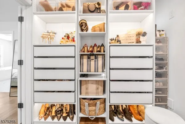 a view of walk in closet with clothes and shoes