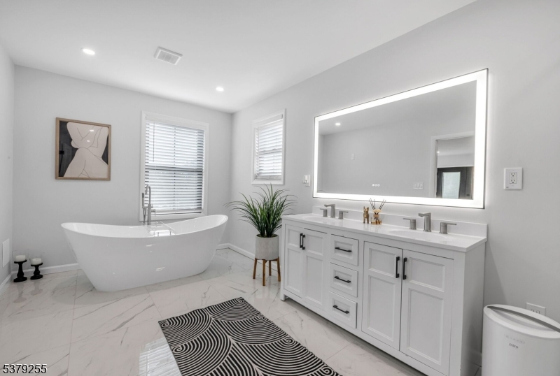648 Black Oak Ridge Road Wayne, NJ 07470 - Photo 29 of 50 a spacious bathroom with a double vanity sink a mirror and a bathtub