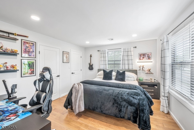648 Black Oak Ridge Road Wayne, NJ 07470 - Photo 35 of 50 a bedroom with a bed a table and a large mirror next to a window