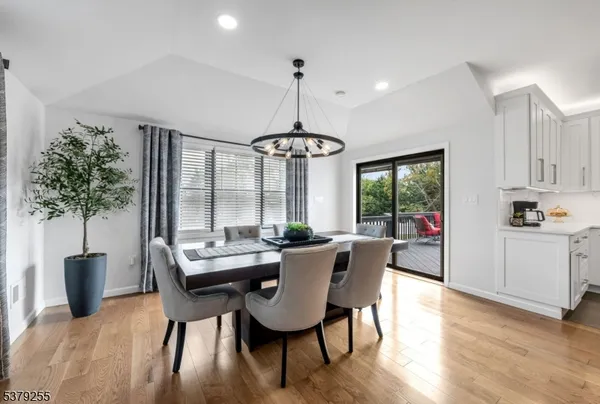 a dining room with furniture a chandelier and wooden floor