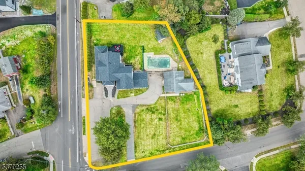 an aerial view of residential houses with outdoor space and trees