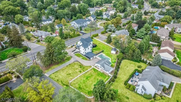 an aerial view of a house with a garden and lake view