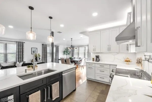 a kitchen with stainless steel appliances granite countertop a sink a stove and a wooden floors