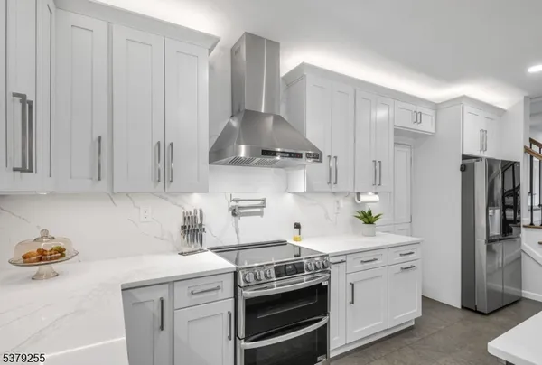 a kitchen with stainless steel appliances a stove a refrigerator and cabinets