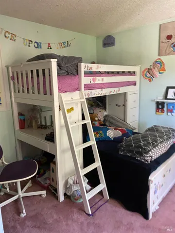 a bedroom with a bed and painting on the wall