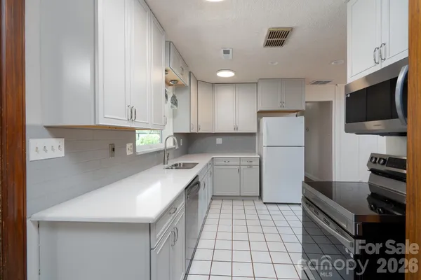 a kitchen with stainless steel appliances granite countertop a refrigerator and a stove top oven