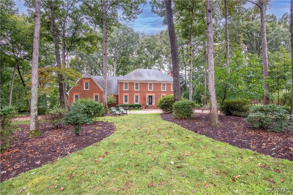 a front view of a house with yard and green space
