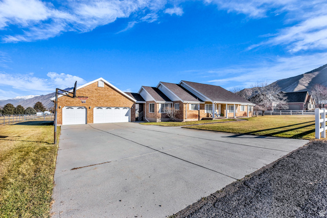 1060 West 2620th Street South Mapleton, UT 84664 - Photo 80 of 87 Ranch-style home featuring a mountain view, a garage, brick siding, and driveway
