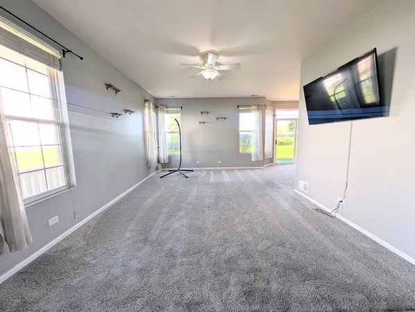 an empty room with windows and fireplace