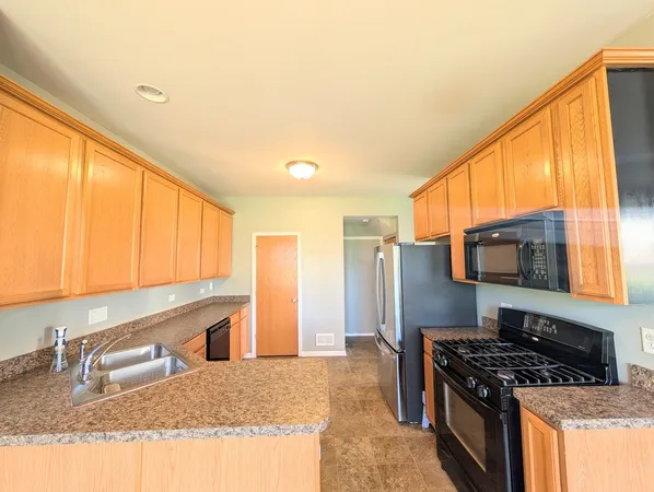 a kitchen with stainless steel appliances granite countertop a stove a sink and a refrigerator