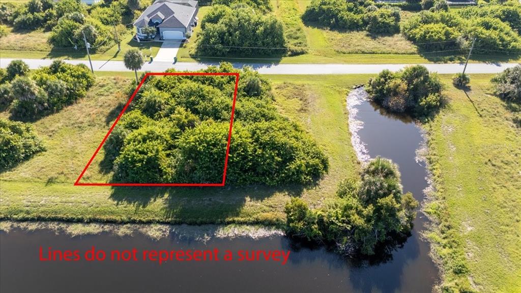153 Spring Drive Rotonda West, FL 33947 - Photo 2 of 13 a view of a lake with a yard and potted plants