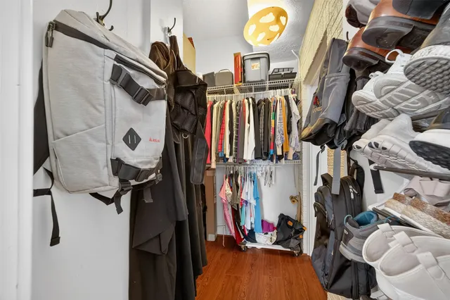 a view of walk in closet with clothes and shoes