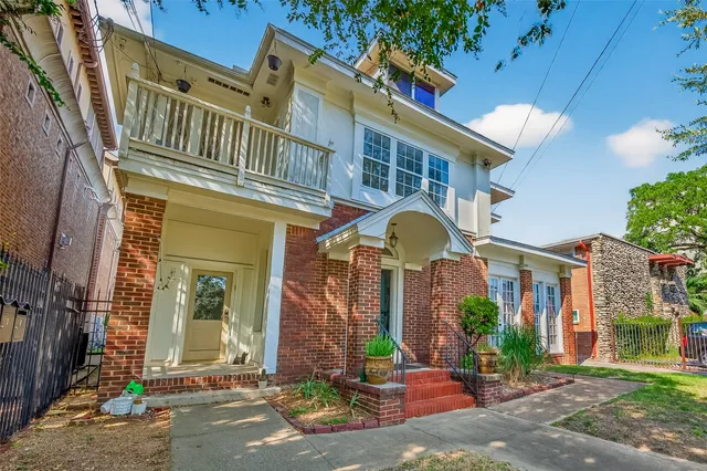 front view of a brick house with a yard