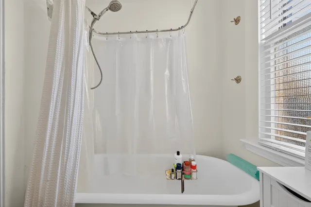 a bath tub sitting next to a white sink and a shower